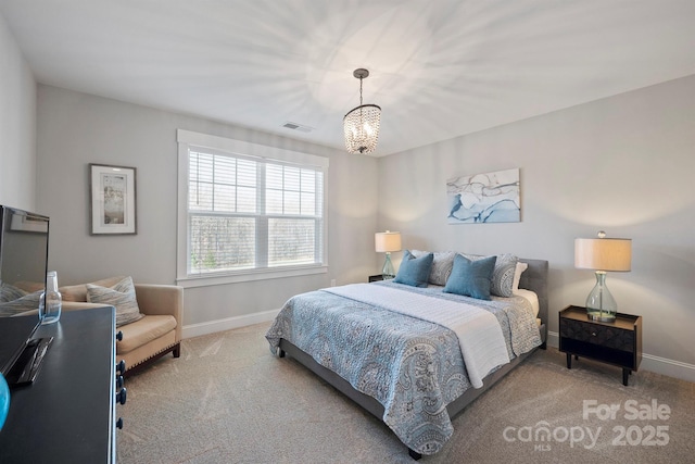 carpeted bedroom featuring a notable chandelier, visible vents, and baseboards