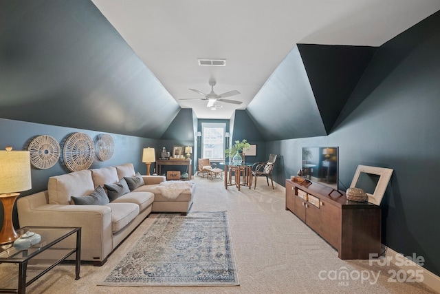 living area with baseboards, visible vents, a ceiling fan, light colored carpet, and vaulted ceiling