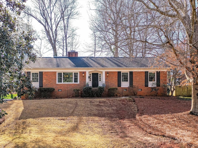 ranch-style home with a chimney, brick siding, roof with shingles, and crawl space