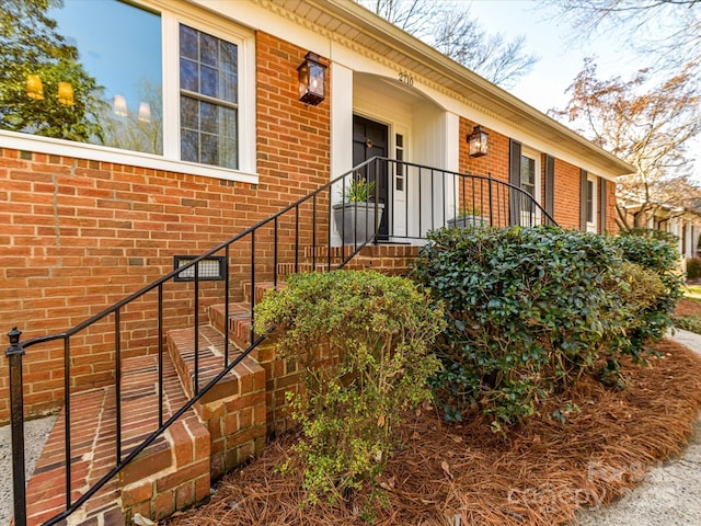 doorway to property featuring brick siding