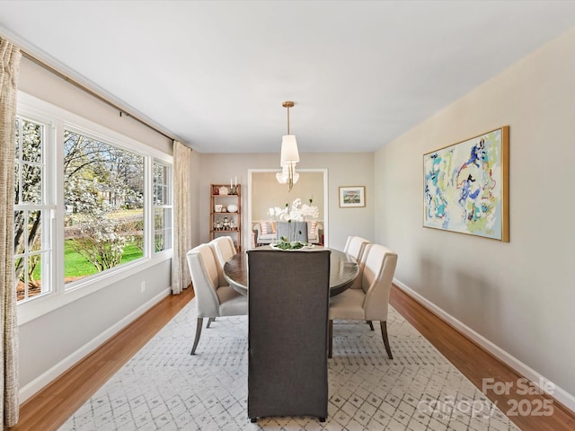 dining area with light wood-type flooring and baseboards