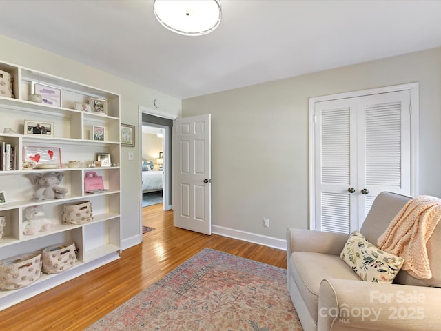 living area featuring light wood finished floors and baseboards