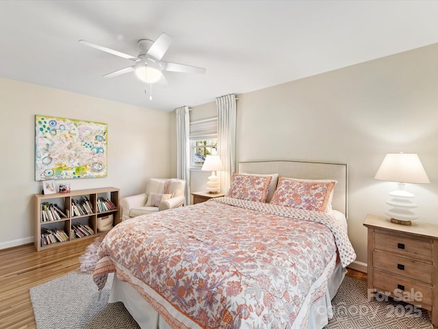 bedroom with a ceiling fan, baseboards, and wood finished floors