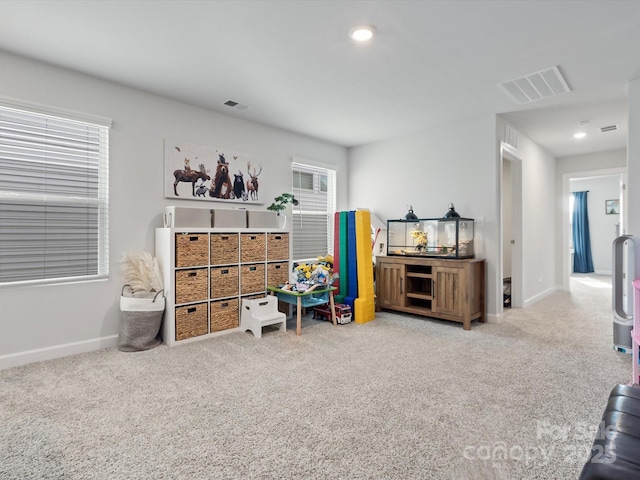 rec room featuring baseboards, visible vents, and carpet flooring