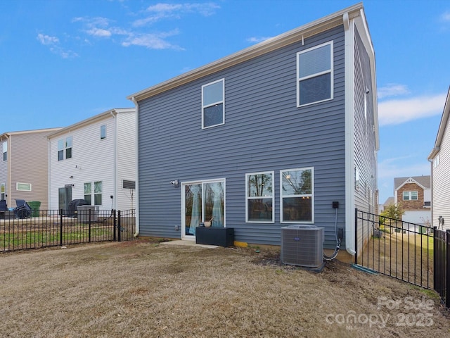 back of property with fence, central AC unit, and a yard