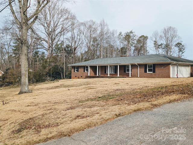 ranch-style house with crawl space, covered porch, brick siding, and an attached garage