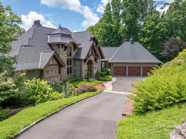 view of front of house featuring stucco siding, concrete driveway, a standing seam roof, metal roof, and a garage