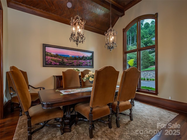 dining space featuring beam ceiling, a notable chandelier, and wood finished floors