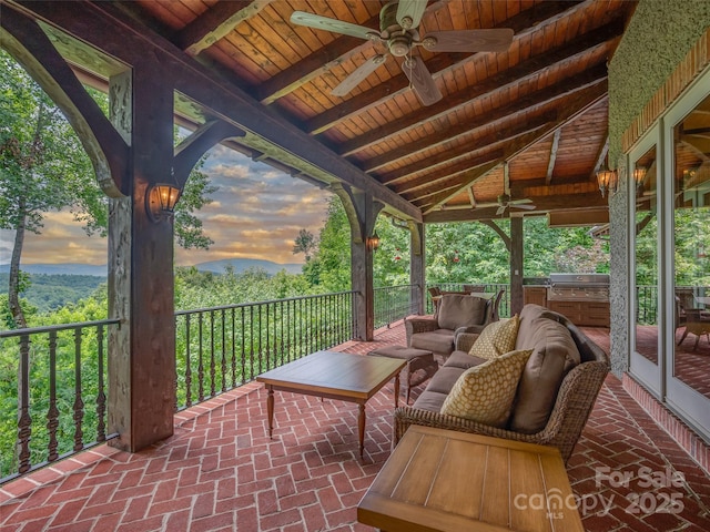 patio terrace at dusk with ceiling fan, outdoor lounge area, and a grill