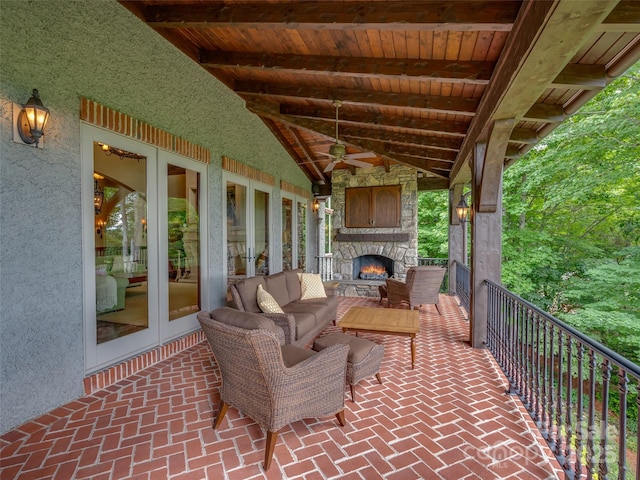 view of patio / terrace featuring ceiling fan, french doors, and an outdoor living space with a fireplace