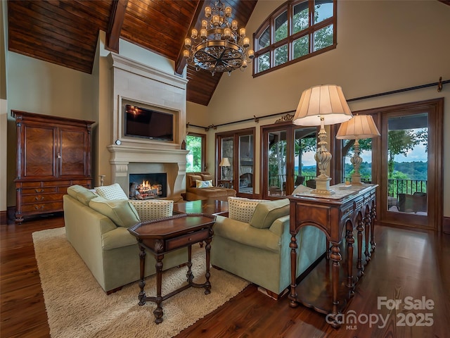 living area featuring a warm lit fireplace, wooden ceiling, a healthy amount of sunlight, and wood finished floors