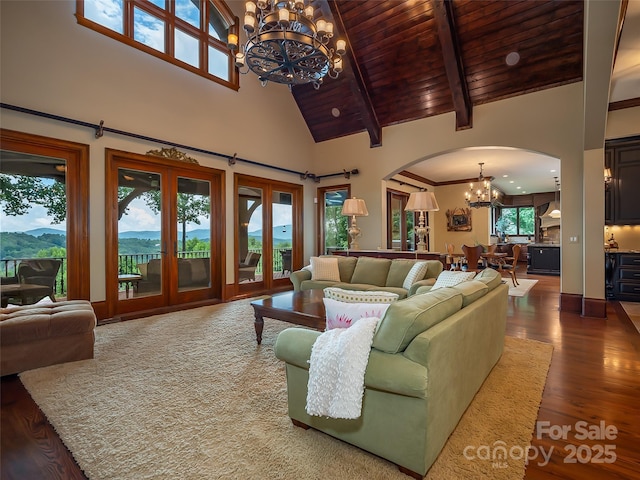 living room featuring arched walkways, high vaulted ceiling, wood ceiling, wood finished floors, and a chandelier