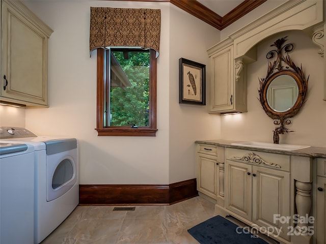 laundry room featuring cabinet space, visible vents, ornamental molding, a sink, and separate washer and dryer