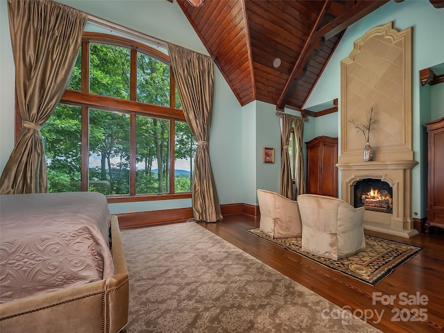 bedroom featuring high vaulted ceiling, a warm lit fireplace, wooden ceiling, and wood finished floors