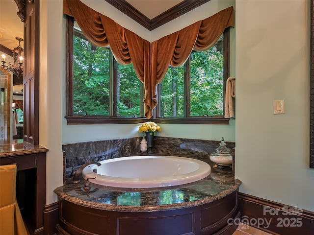 full bathroom with ornamental molding, a notable chandelier, and a bath