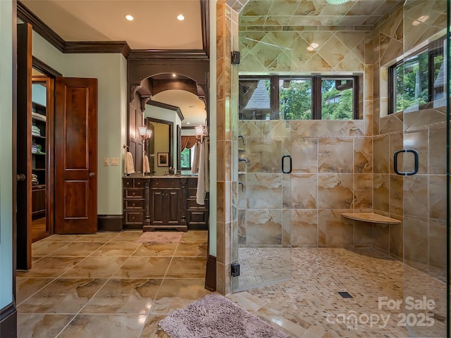 bathroom with ornamental molding, a shower stall, vanity, and baseboards