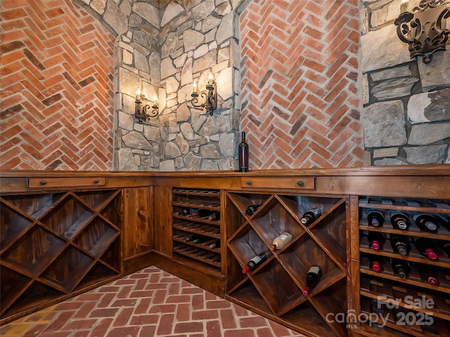 wine cellar with a wainscoted wall, wood walls, and brick floor