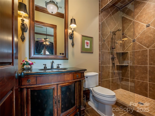 bathroom with tiled shower, vanity, and toilet