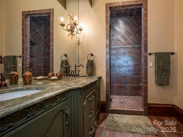 bathroom featuring a stall shower, tile patterned flooring, baseboards, and vanity