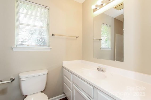 bathroom featuring a healthy amount of sunlight, toilet, and vanity