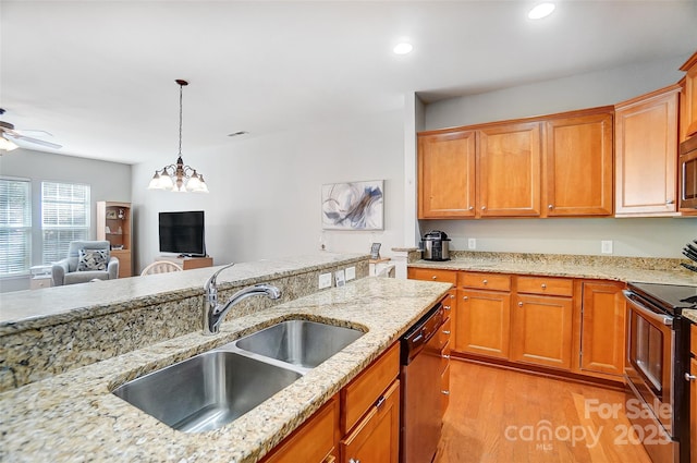 kitchen featuring light wood finished floors, ceiling fan, appliances with stainless steel finishes, hanging light fixtures, and a sink