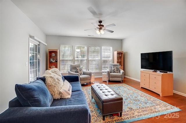 living room with a healthy amount of sunlight, baseboards, and wood finished floors