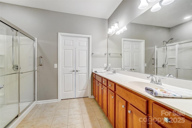 bathroom featuring a stall shower, tile patterned flooring, and a sink