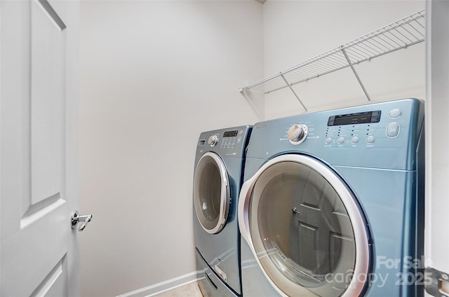 clothes washing area featuring laundry area, washing machine and clothes dryer, and baseboards