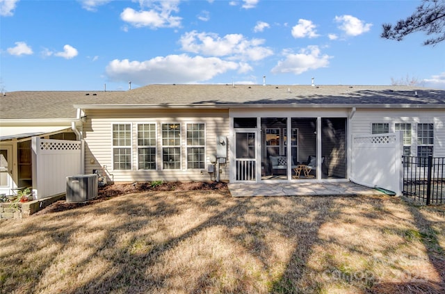 rear view of house with a lawn, a sunroom, a patio area, fence, and cooling unit