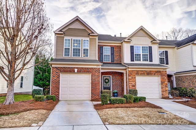 view of front of home featuring a garage, concrete driveway, brick siding, and board and batten siding