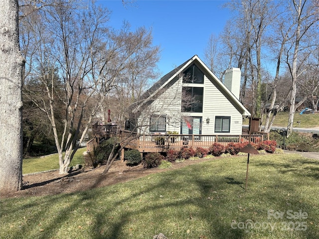 view of front facade featuring a chimney, a wooden deck, and a front yard