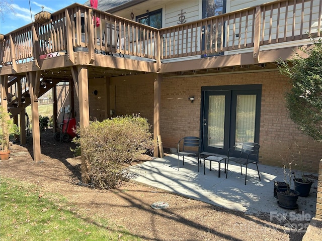 rear view of property with a patio, brick siding, and a deck