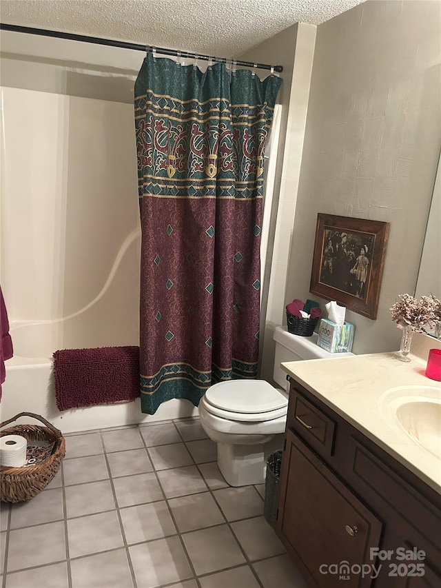 bathroom with tile patterned floors, a textured ceiling, vanity, and toilet