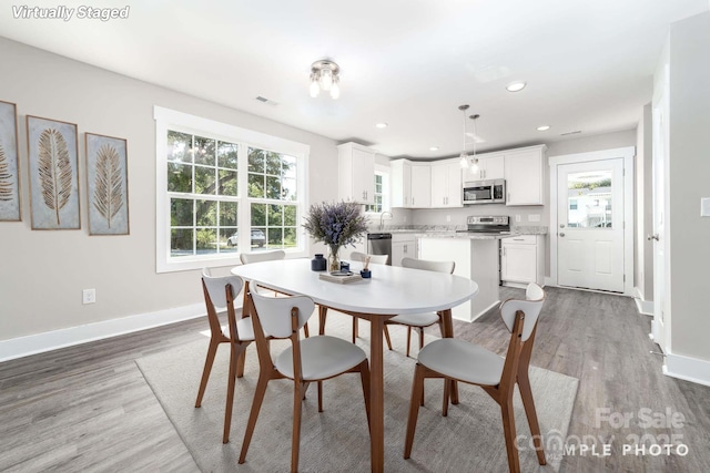 dining area featuring visible vents, baseboards, wood finished floors, and recessed lighting