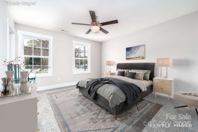 bedroom with ceiling fan, baseboards, visible vents, and carpet