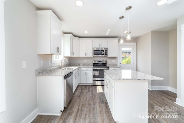 kitchen featuring white cabinets, stainless steel appliances, baseboards, and a sink