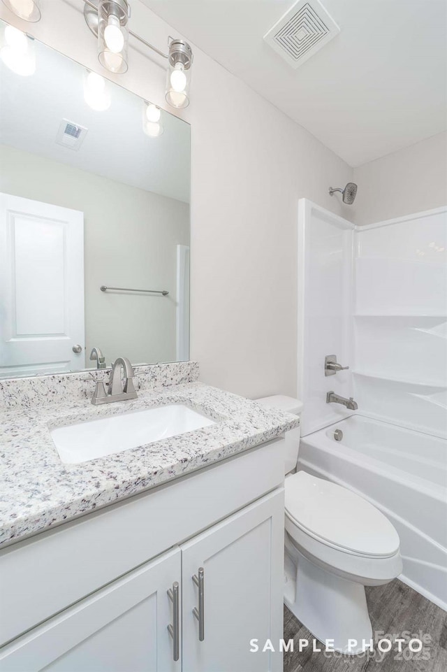 bathroom featuring visible vents, toilet, vanity, and  shower combination