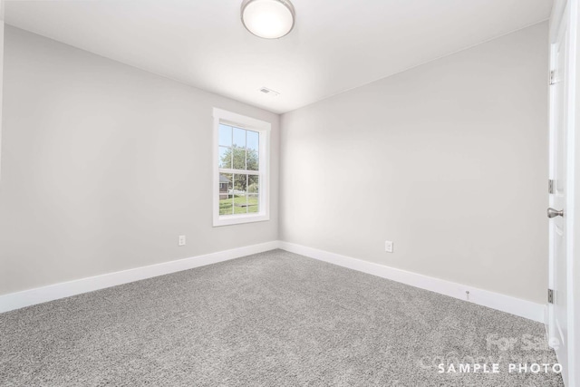 spare room with carpet and baseboards