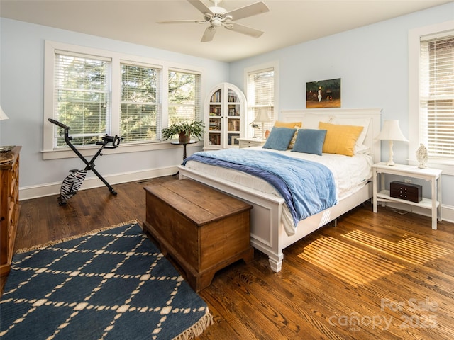 bedroom with ceiling fan, baseboards, and wood finished floors