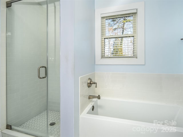 full bathroom featuring a garden tub and a shower stall