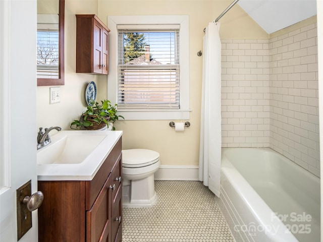 bathroom with baseboards, vanity, toilet, and shower / bath combo with shower curtain