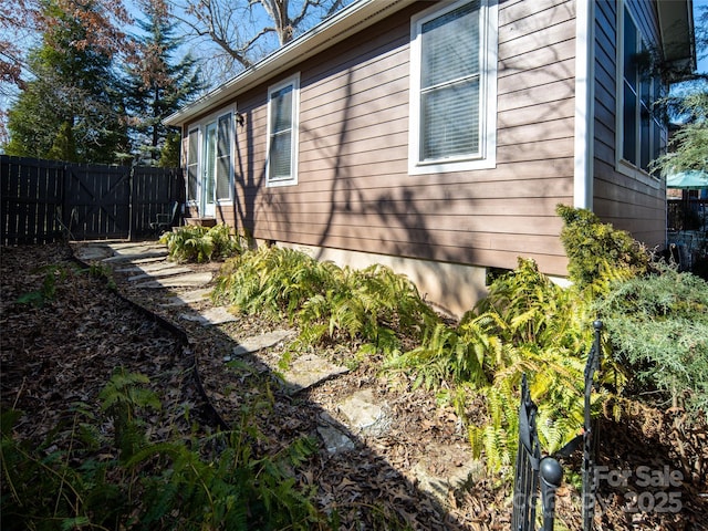 view of home's exterior featuring entry steps and fence