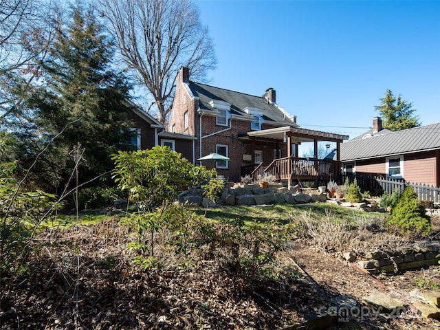 back of property with brick siding, a chimney, fence, a deck, and a pergola