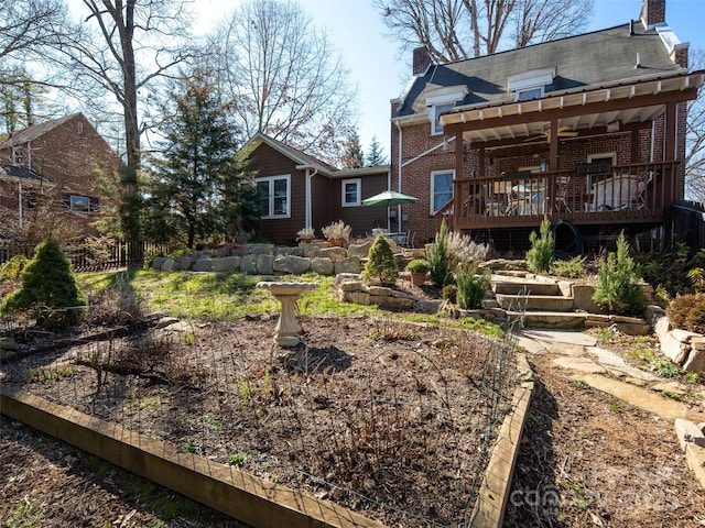 rear view of house featuring a deck, brick siding, and a chimney