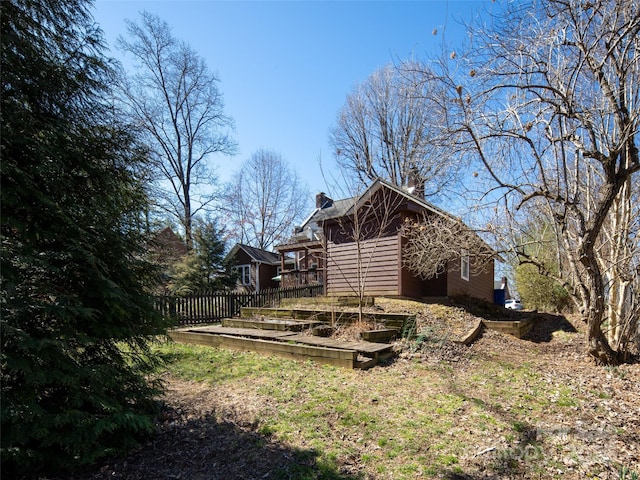 back of property with fence and a chimney