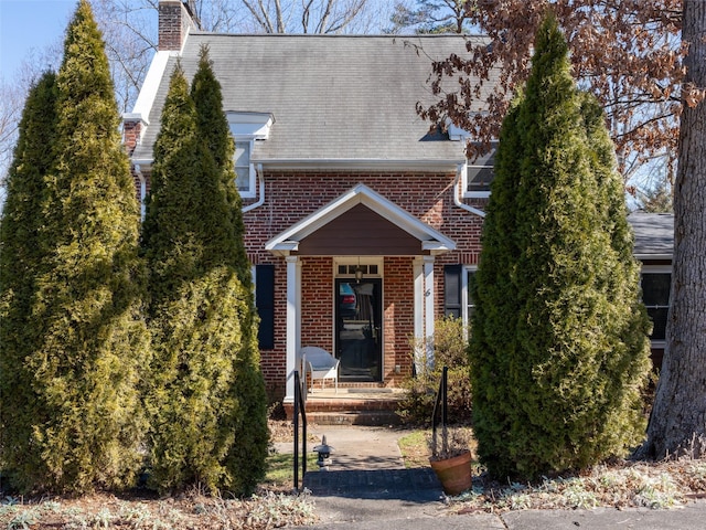 view of front of property with brick siding and a chimney