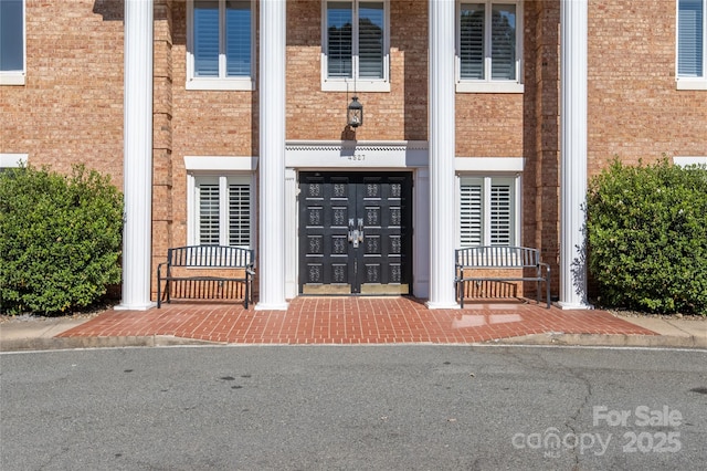 view of exterior entry featuring brick siding