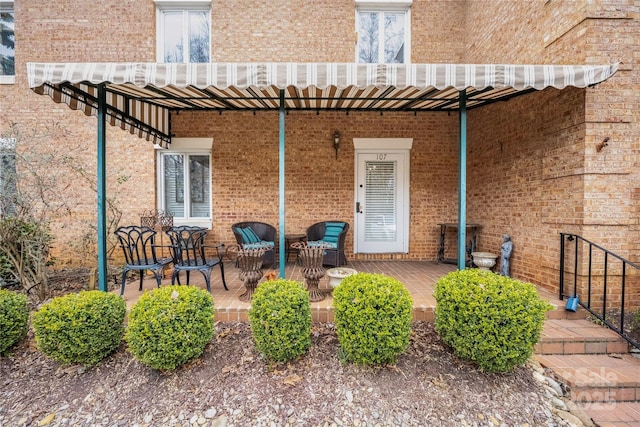 entrance to property with a patio and brick siding