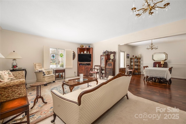 living room featuring ornamental molding, wood finished floors, a wealth of natural light, and an inviting chandelier