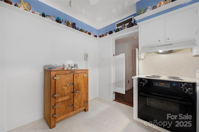 kitchen with range with electric stovetop, light floors, light countertops, white cabinets, and under cabinet range hood